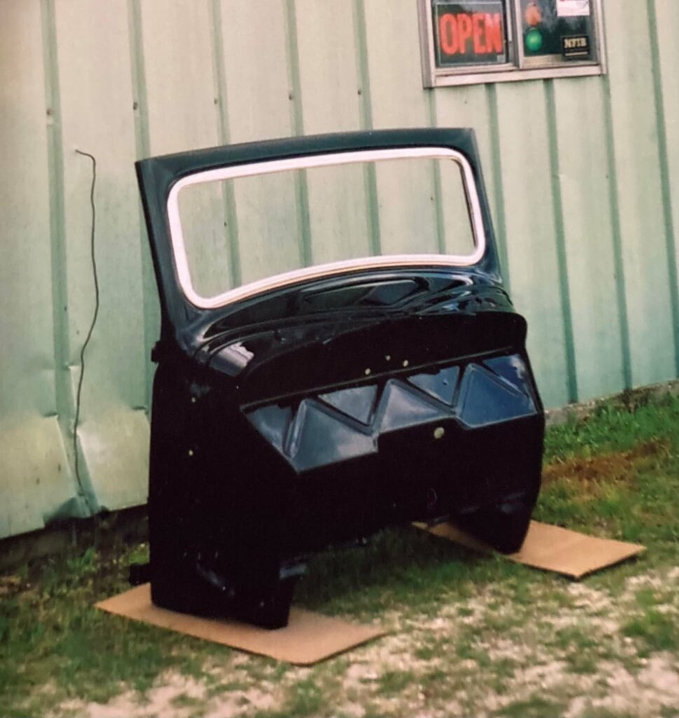 Ron Corder Customs A black car parked in front of a building.